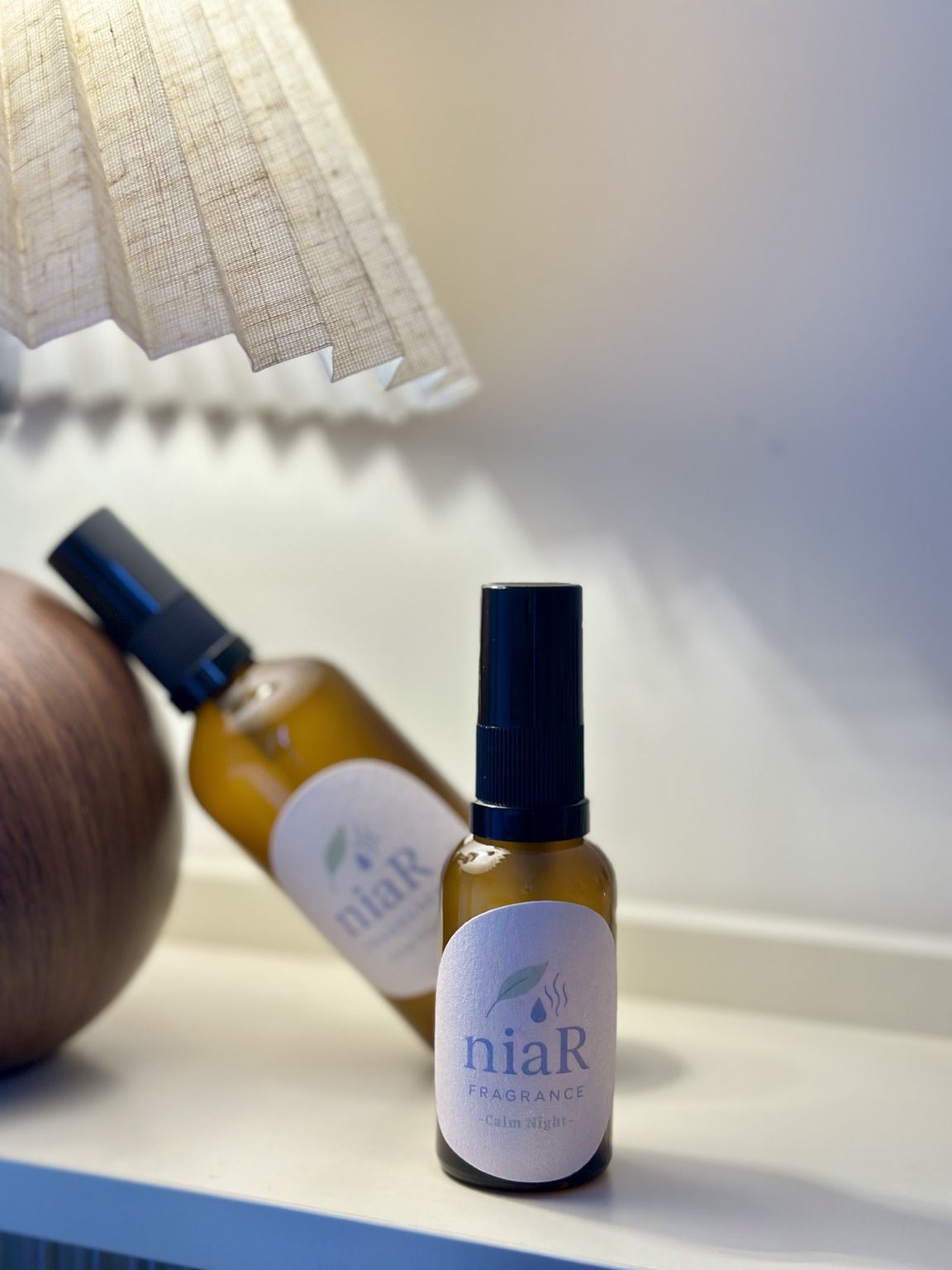 niaR 睡眠噴霧實拍：燈光下的棕色噴霧瓶與品牌標籤